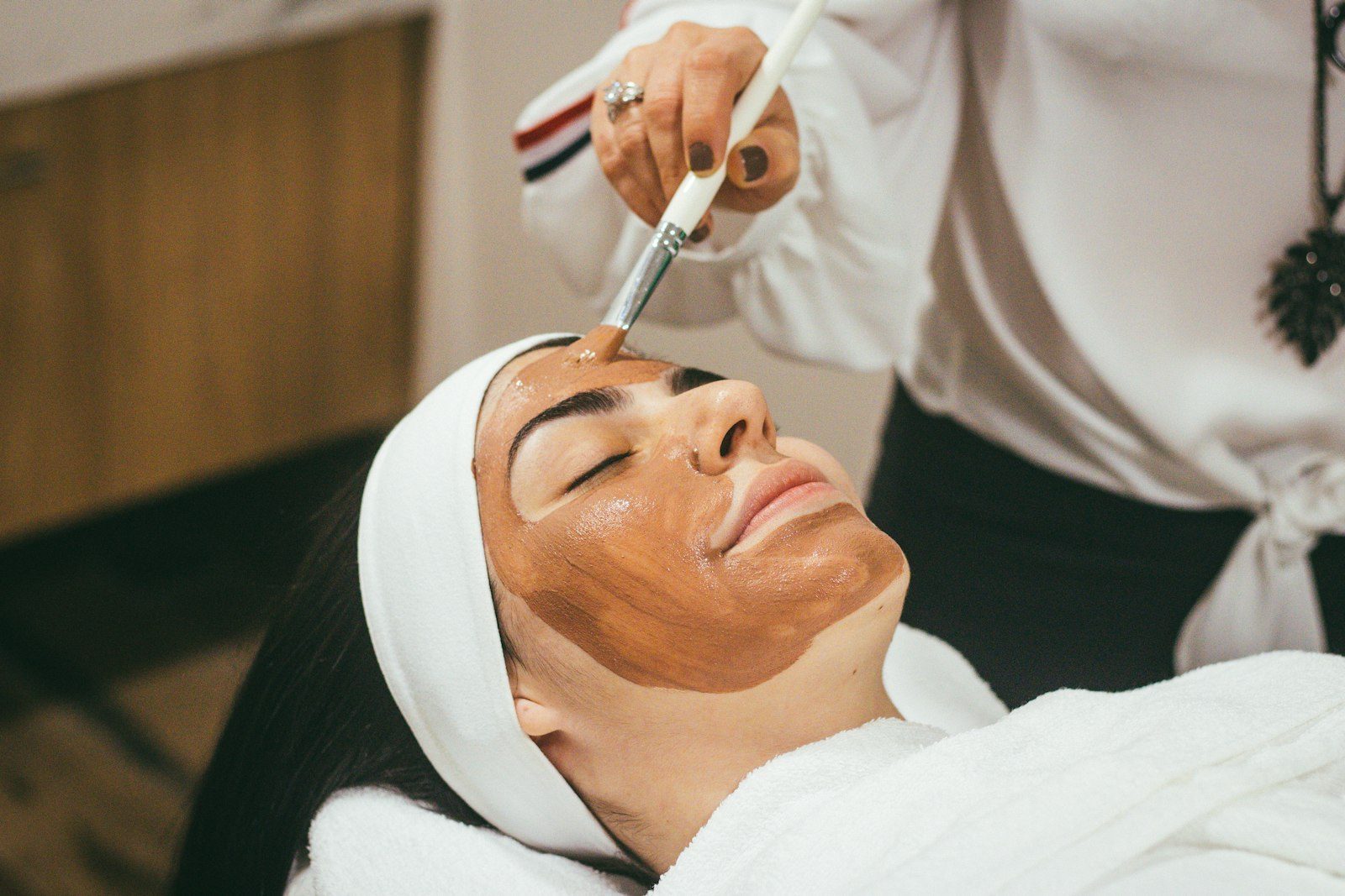 A facial mask being applied with a brush