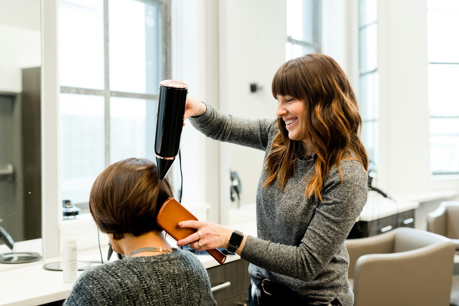 A stylist blow-drying a client's hair